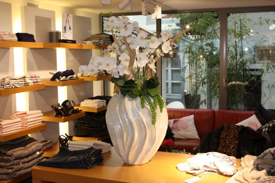 Innenbegrünung einer boutique mit künstlichen Orchideen.