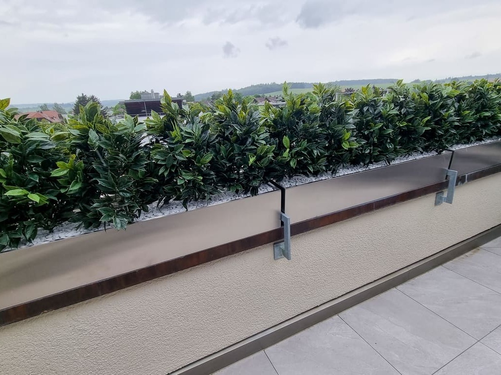 Begrünung Balkongeländer Sichtschutz mit künstlichen Heckenpflanzen in Chromstahl Pflanzgefässe auf einem Balkon in der Schweiz.